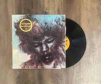 Vinyl record LP and album cover of 'The Cry Of Love' by Jimi Hendrix, showing front cover artwork and record disc partially out of the sleeve.