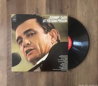 Vinyl LP record partially pulled out of the original album cover sleeve featuring Johnny Cash on the front.