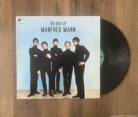 Top-down photo of 'The Best Of Manfred Mann' vinyl record and cover on wood surface.