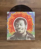 Front cover of vinyl record showing the album art and one of the vinyl discs partially visible above the cover.