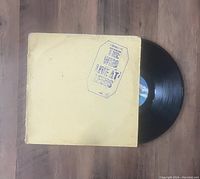 Black vinyl record with off-white sleeve showing the title stamp 'The Who Love At Large'