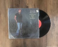 Photo showing the front of the vinyl album cover with vinyl record partially visible.