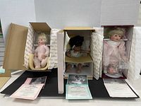 Three Ashton-Drake collector dolls in their original packaging each with a Certificate of Authenticity displayed in front
