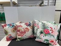Two sets of decorative cushions with bright tropical and floral patterns, arranged for photo