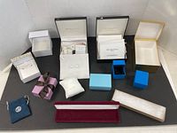 Full collection of various jewelry gift boxes displayed on black surface, showing different shapes and colors.