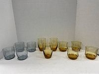 Group photo showing five amber and five grey Mid-Century Modern style textured glass tumblers arranged in two rows on a neutral background.