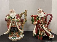 Both Santa figurines side by side with handles visible