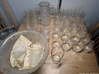 Photo showing all glassware items including punch bowl, pitcher, and glasses arranged on wooden table