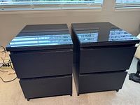 Pair of black contemporary lamp tables with removable glass tops shown side by side.
