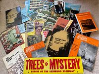 Wide view of collection showing postcards, historical booklets, magazines, and ephemera approximately 40 items.