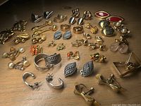 Image showing wide assortment of clip-on earrings including faux pearl, gold-tone leaf, silver-tone patterned, and red enamel styles.