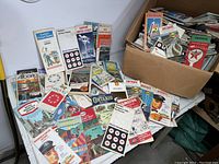 Photo showing a large number of vintage road maps, laid out and stacked. Visible brands include Esso, Sunoco, Mobil, with maps for Ontario and Quebec.