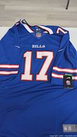 Front view of blue Nike NFL Buffalo Bills jersey with number 17 and Bills text on chest, size XXL tag visible bottom left.