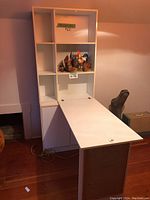 White convertible desk with shelf compartments, fold-down desk surface extended, and storage cabinet below.
