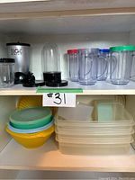 Magic Bullet blender base and blender cups with lids on shelf