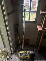 Full view of McCulloch high pressure jet sprayer with attached hose and nozzle inside shed.