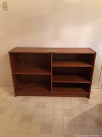 Front view of teak bookshelf showing two compartments and shelves