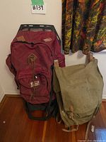 Two backpacks shown together; one maroon with black frame, and one green canvas.