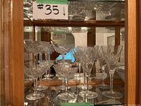 Display cabinet showing 11 Waterford Crystal stemware glasses, including champagne flutes and champagne coupes.