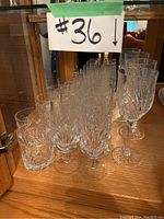 Entire lot of Waterford crystal stemware and glassware in display cabinet, showing different styles and quantities.