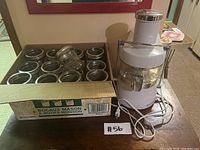 Box of wide mouth Mason jars with metal lids, showing multiple jars upright and some laying down with lids off.