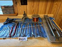Wrenches, pliers, pipe cutter, and puller tool laid out on a counter