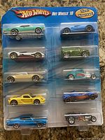 Front view of the unopened blister pack containing 10 Hot Wheels cars in various colors and models.