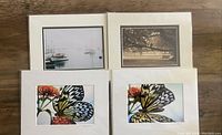 Four matted 5x7 nature photography prints arranged on a wooden surface, featuring butterflies and landscapes.