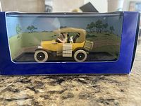 Side view image of the model car in original packaging showing Tin Tin driving with his dog beside him.