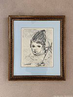 Full framed monochrome sketch painting of a young child, signed Cucaro, with ornate gold frame and blue matting.