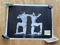 Full view of black and white ballet poster held flat with weights to show condition and detail