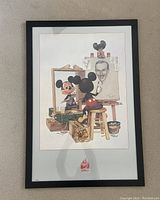 Framed Walt Disney Mickey Mouse self portrait poster by Charles Boyer, showing Mickey Mouse painting Walt Disney, in a black frame with white matting.
