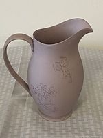 Full side view of the Wedgewood Lilac Jasper Jug showing its shape, handle, spout, and floral relief decoration on the body.