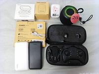All items displayed together to show contents of the bundle including drone with controller in case, power banks, earbuds, travel adapter, charger, and portable speaker.