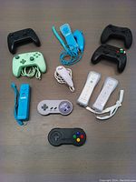 Top view of all controllers laid out on the table, showing 4 generic wireless controllers, 4 Wii motion sensing controllers with nunchuks, 2 wireless SNES controllers