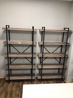 Front view of two assembled Walker Edison bookcases showing 5 shelves each and black metal frames.