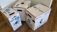 Three boxes of network cables placed on the floor showing different brands and types such as Cat 5e and Cat 6 cables