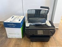 Box of Hammermill Premium Color Copy Paper next to HP ENVY 7640 copier on floor