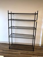 Front view of Uline metal shelving unit showing five wire mesh shelves and vertical posts.