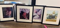 Four black framed pictures showing Ralph Lauren children's shoe fashion photography resting on floor.
