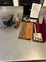 Bench vise at left, hand plane and precision tools at right on metal surface