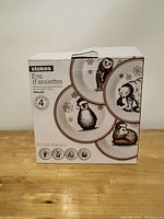 Photo of packaging box showing Stokes brand and set of 4 porcelain dessert plates featuring festive animals with snowflakes.