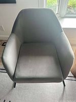 Top-down view of the grey fabric armchair showing seat cushion, armrests, and part of black metal legs.