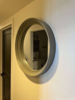 Side angle view of the round mirror showing thickness and layered design of the white frame.