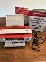 HP DeskJet 3755 wireless photo printer with power cord and original box on wooden table.