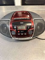 Front view of RCA stereo player showing speakers, display, and control buttons.