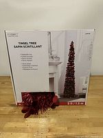 Box of Celebrate It brand 5ft collapsible red tinsel Christmas tree showing product image and specifications.