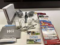 Full lot arranged showing console, controllers, cables, manual and game cases