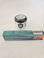 Photo of two products: Wise Men Calm Balm in a white jar with black lid, and Aroamas Advanced Medical Silicone Scar Gel in box packaging.