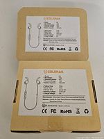 Photo showing two unopened Colerak H2 boxes with product specifications on the back including battery capacity, Bluetooth version, talk and music times.